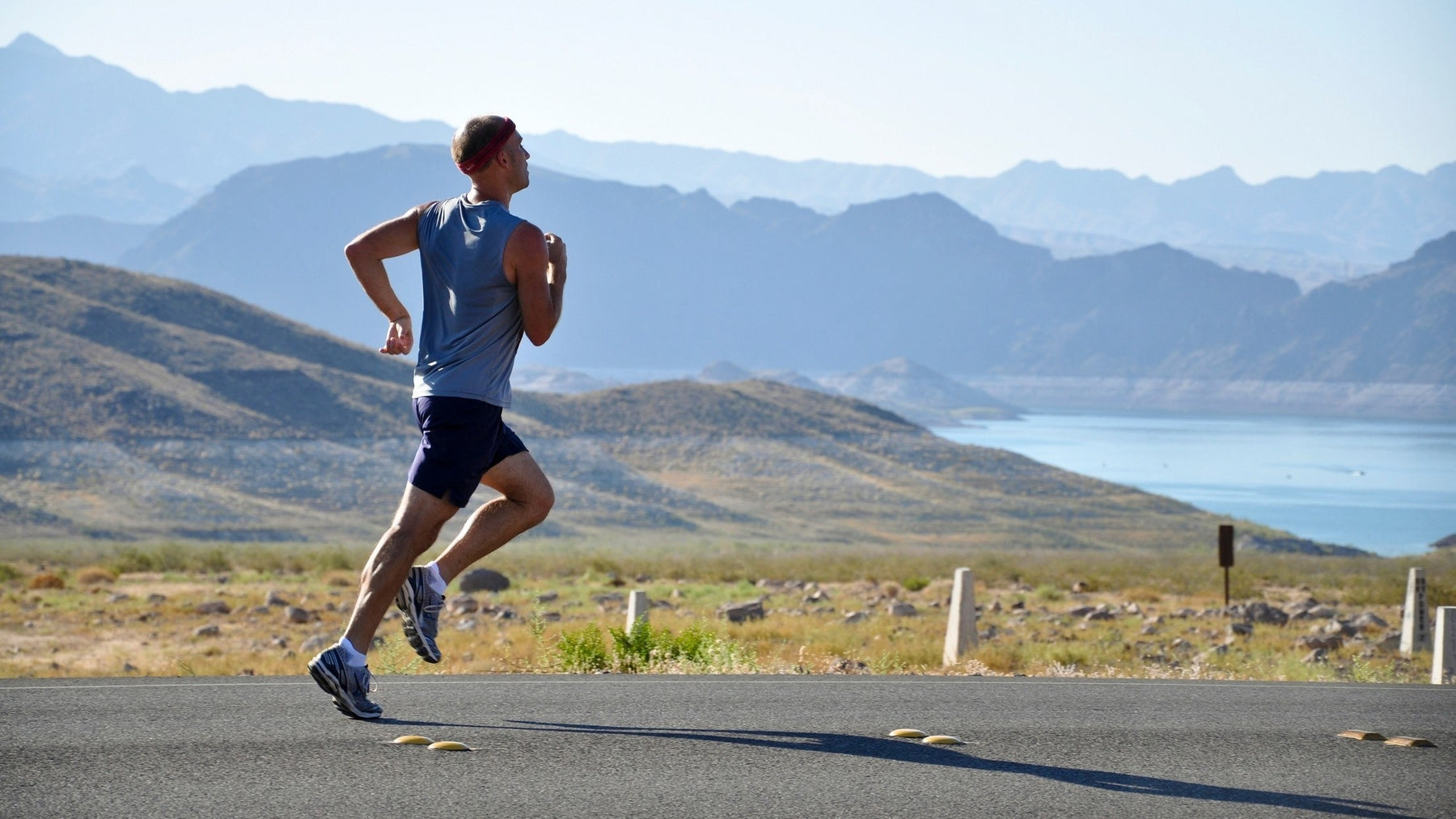 Man running outside with a mountain in the background