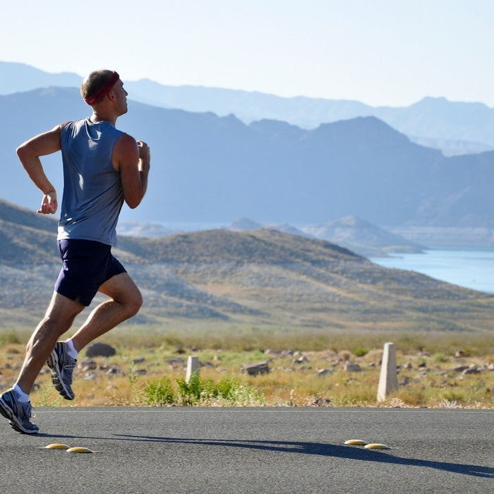 Man running outside with a mountain in the background