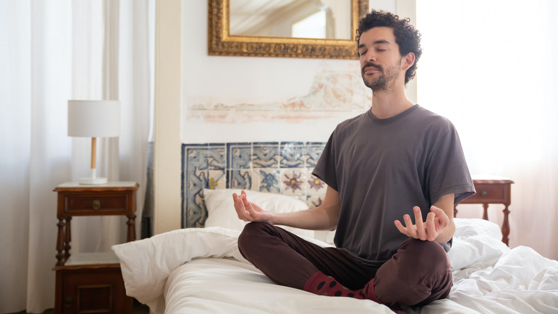 Man meditating on a bed