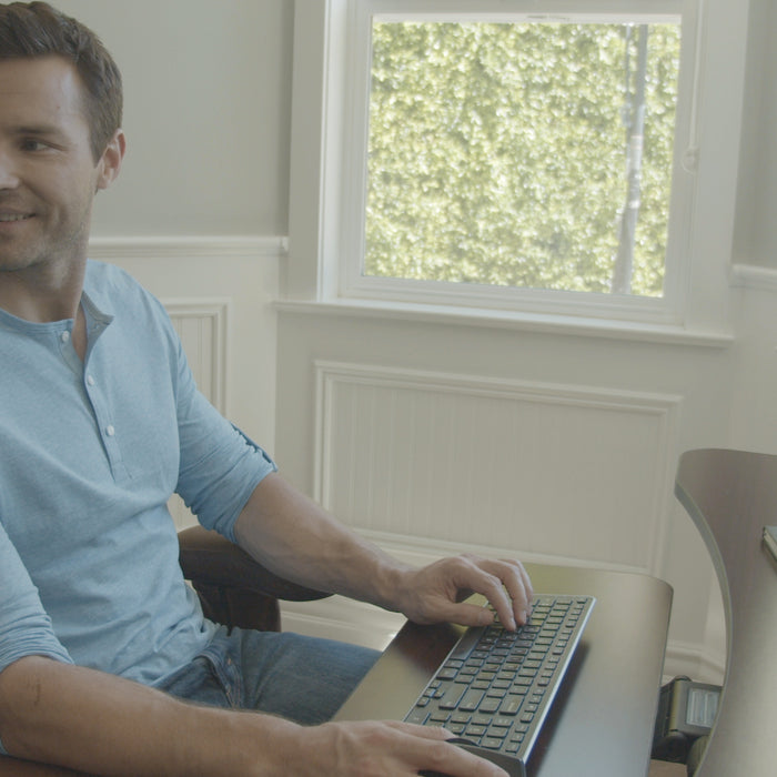 Man sitting on a Mid Back Executive Office Chair by Lifeform at his desk