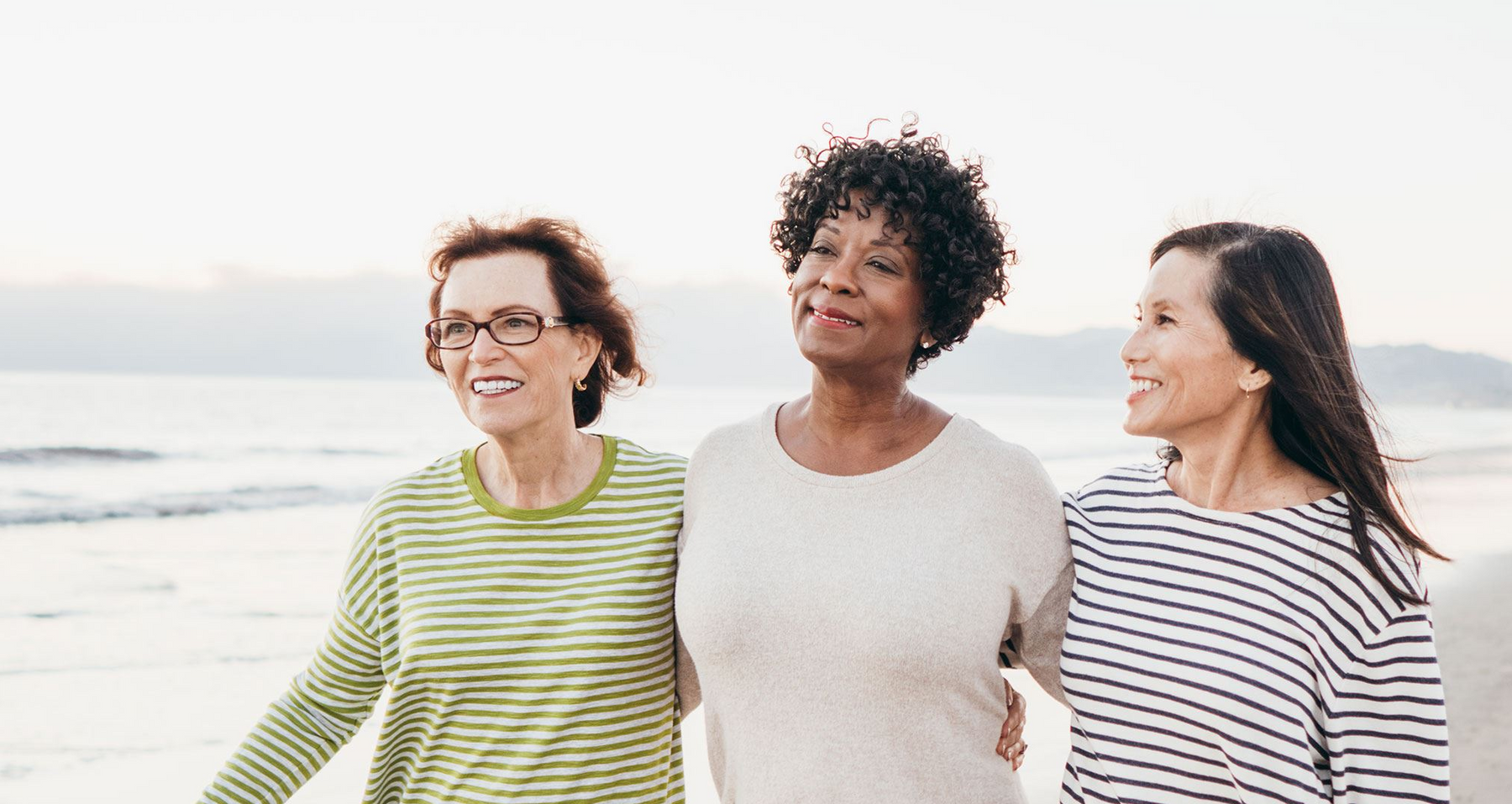 Three women walking on a beach