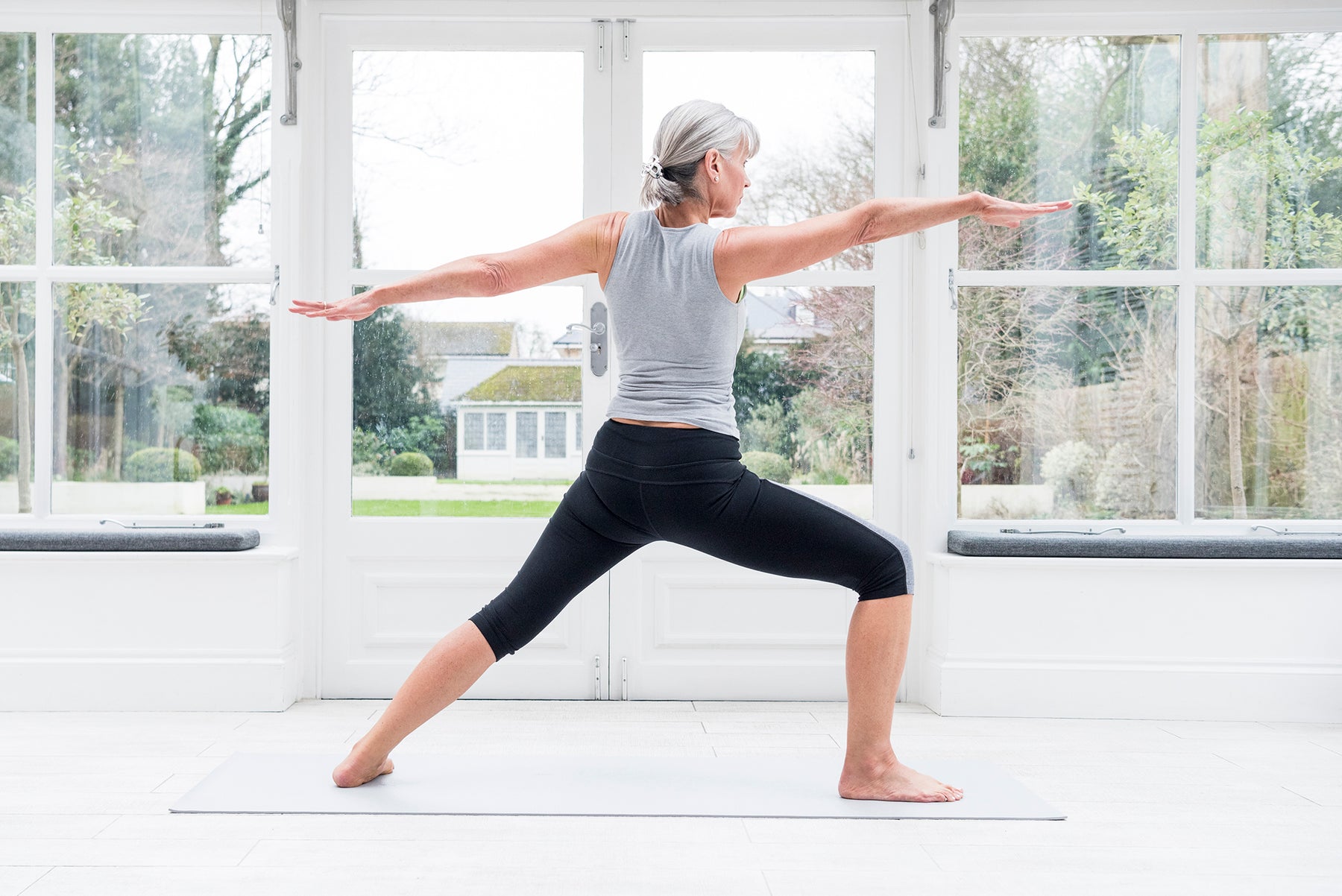 A woman practicing yoga in her home.