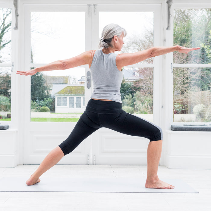 A woman practicing yoga in her home.